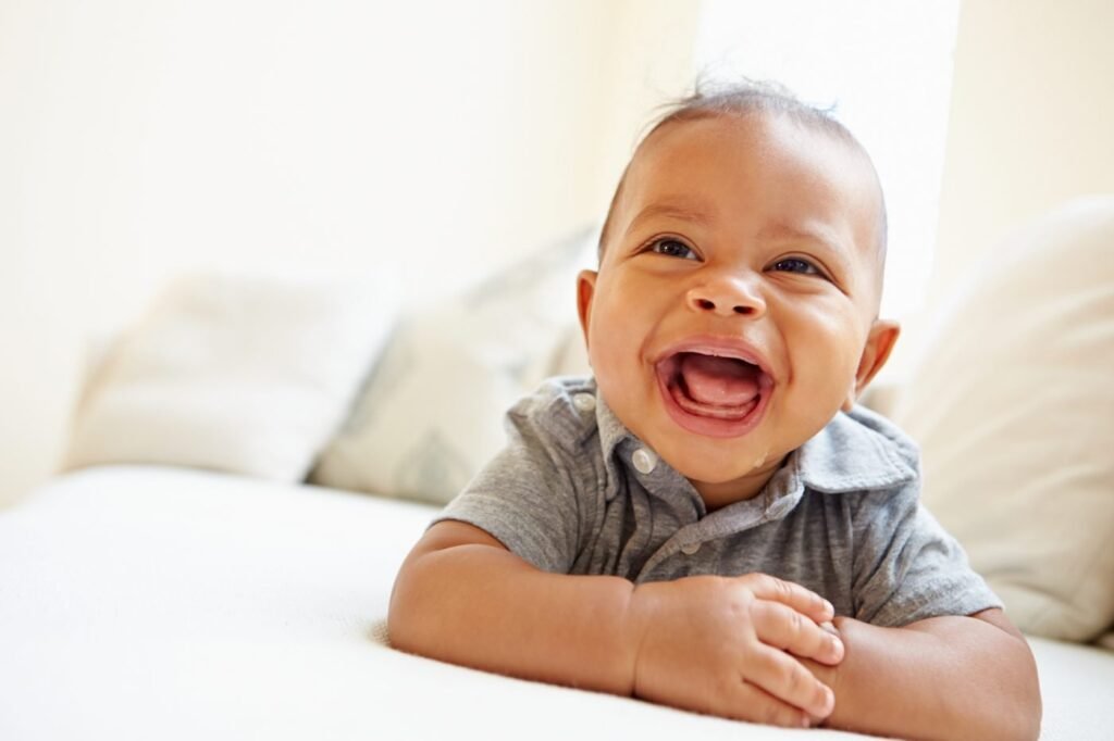Bebê menino feliz e sorridente, representando a busca por nomes masculinos com significado cristão para 2026, um ano de novas tendências.