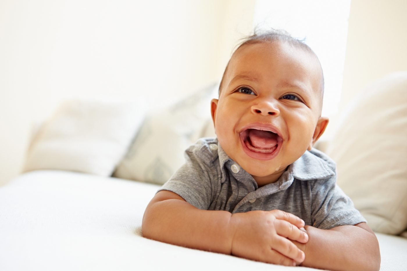 Bebê menino feliz e sorridente, representando a busca por nomes masculinos com significado cristão para 2026, um ano de novas tendências.