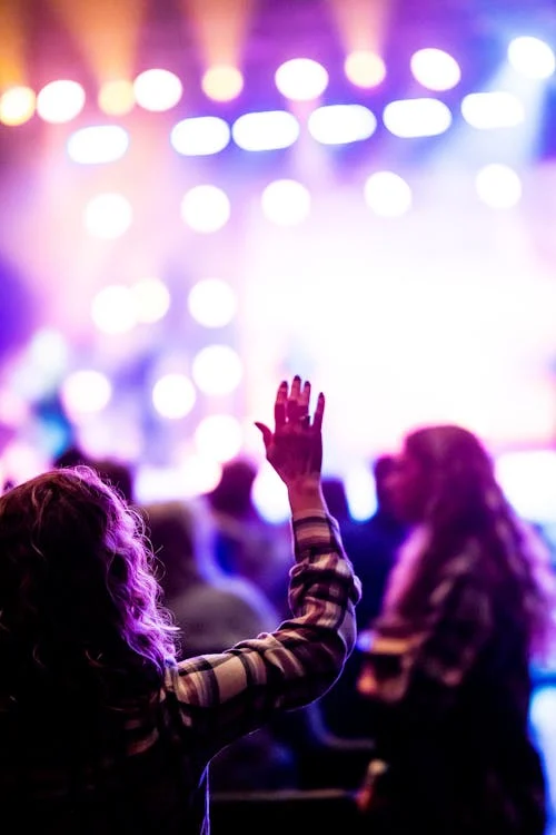 Cantor gospel no palco, liderando um momento de louvor e adoração. A imagem representa shows gospel e lives, promovendo avivamento espiritual e fé na agenda gospel da semana.